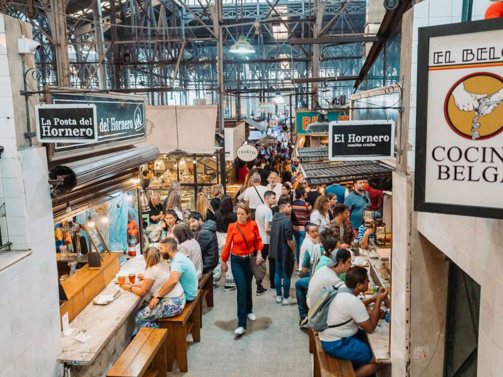 Looking down the aisle of an indoor market with restaurants on either side