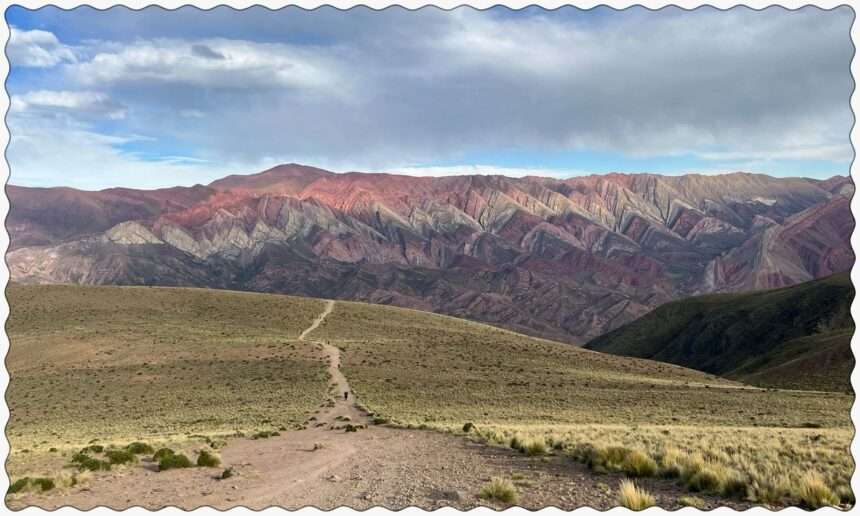 A grassy hill in front of a colorful mountain in Humahuaca