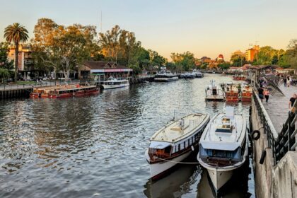 Several boats docked on water in front of a city skyline, creating a picturesque scene - Tigre Buenos Aires