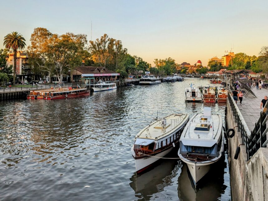 Several boats docked on water in front of a city skyline, creating a picturesque scene - Tigre Buenos Aires