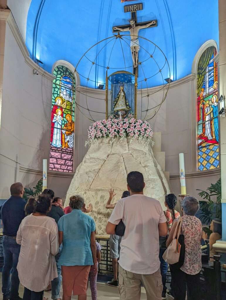 People praying to the Virgin Mary at the Caacupe Cathedral after a pilgrimage to the church as seen as part of the Circuito de Oro