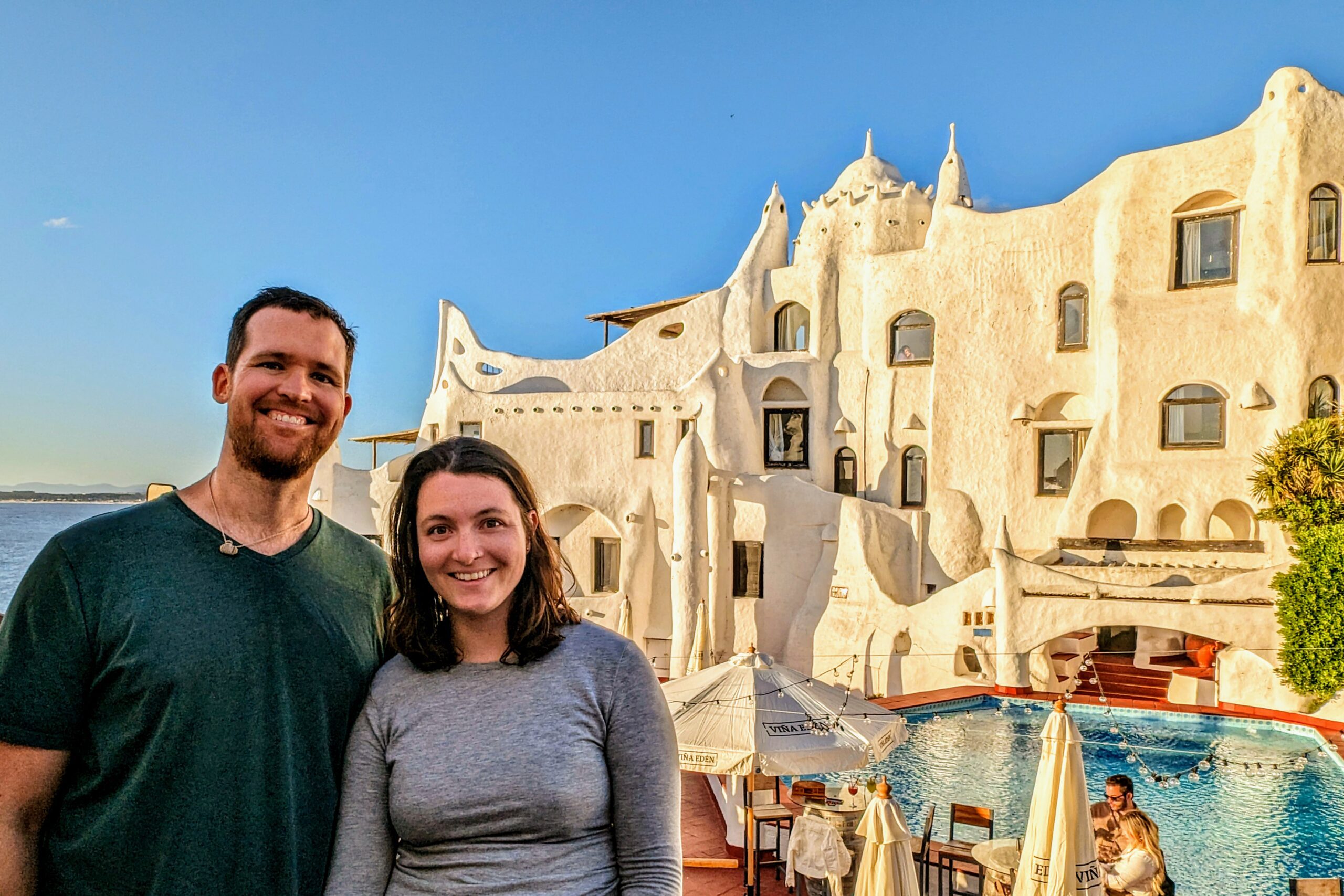 Two people standing on front of the unique architecture of Casapueblo, a white eclectically built building - Things to do in Punta del Este