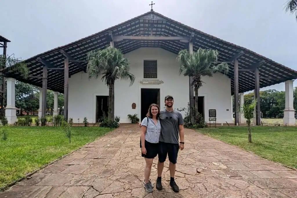 Standing in front of the Templo de San Buenaventura, a wooden church that is part of the Circuito de Oro in Paraguay
