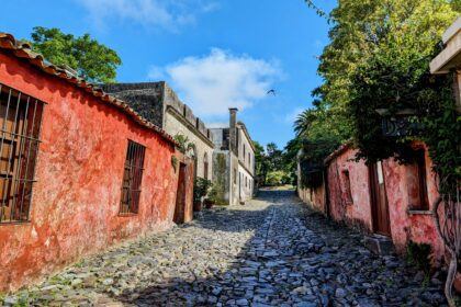 An old historic street in a former Spanish colony with cobblestone streets and red painted homes - Colonia del Sacramento