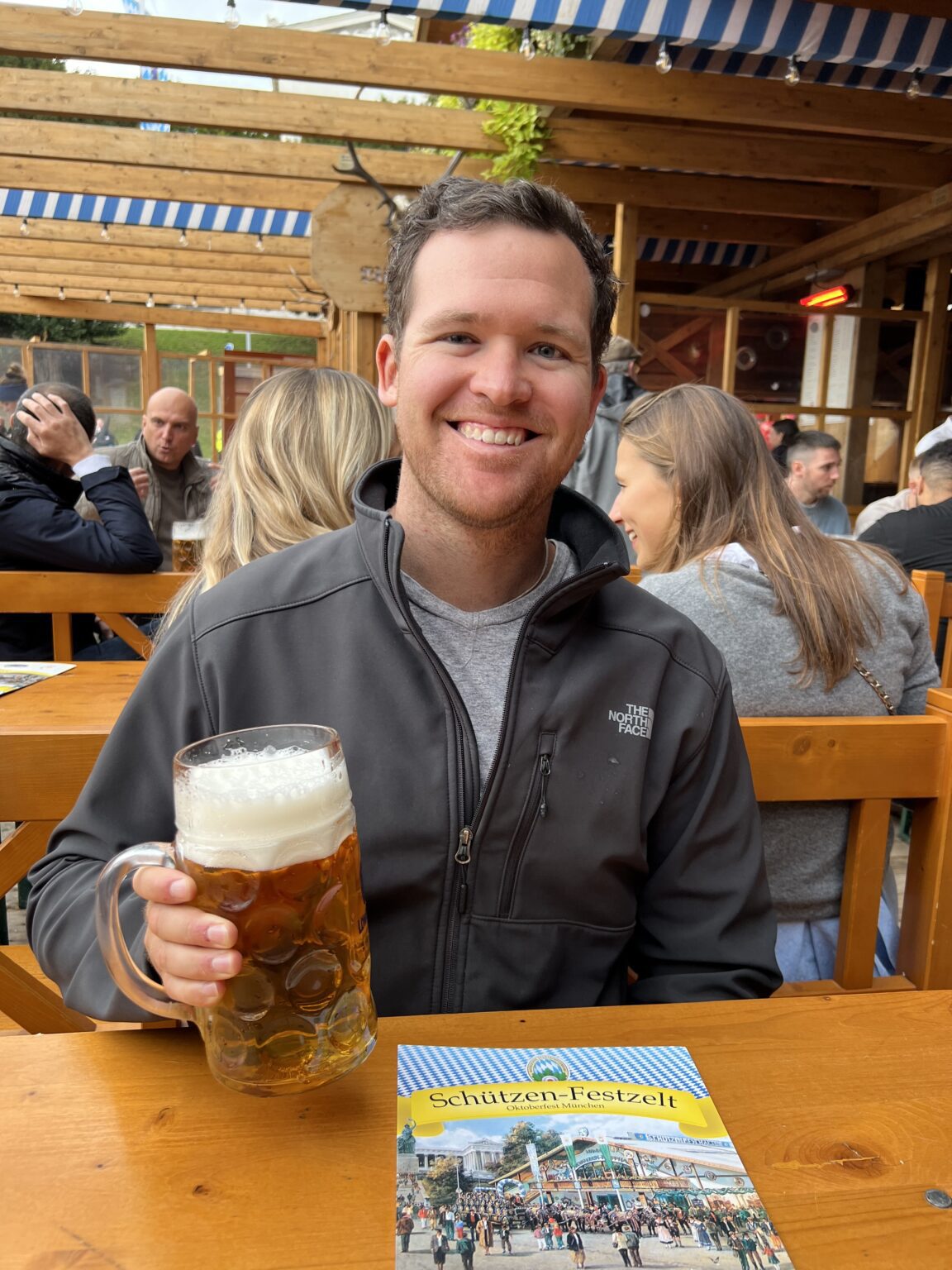 A man smiling and holding a beer