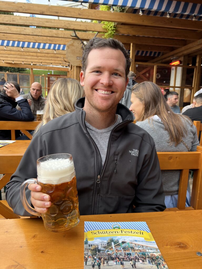 A man smiling and holding a beer