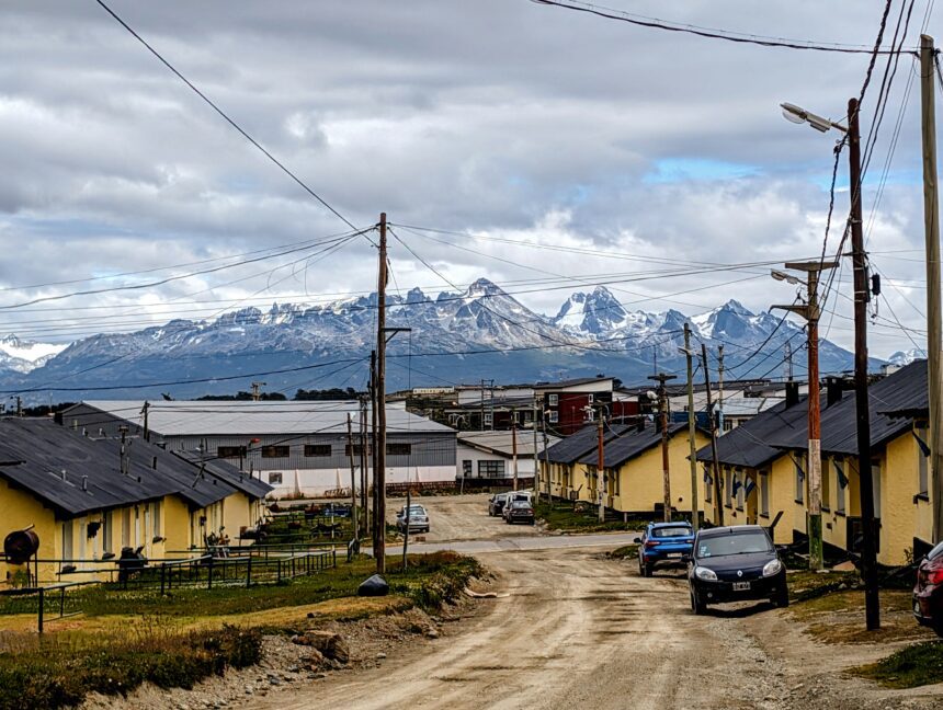 A dirt road going through town with large mountains in the background - best things to do in Ushuaia