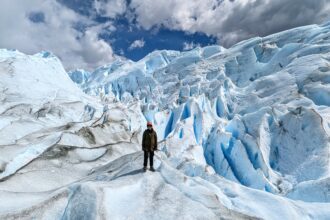 A person standing amidst a large glacier - perito moreno mini trekking