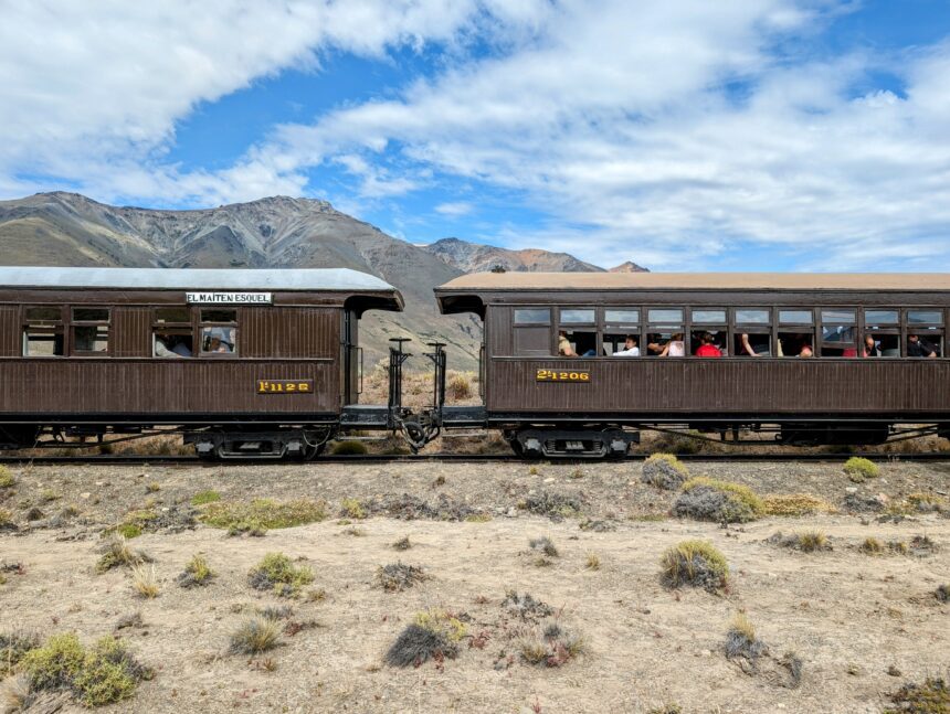 Two train cars sitting on a desert landscape - Esquel, Argentina