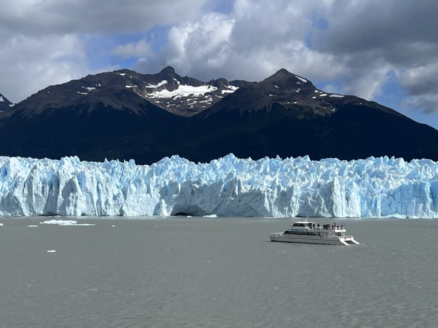 A boat sailing near a glacier in the water.