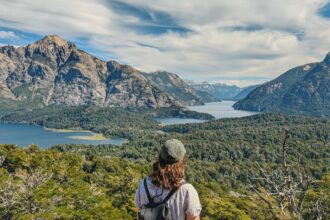 A girl overlooking a valley with some lakes and forests surrounded by beautiful mountains - Circuito Chico