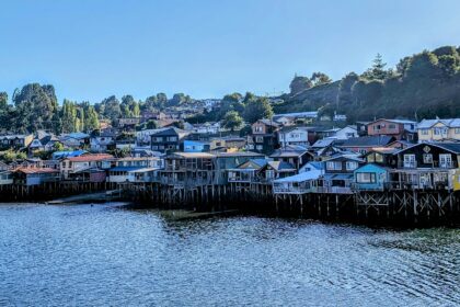 A large grouping of houses on the edge of a shore with stilts going in to the water - Chiloe Island