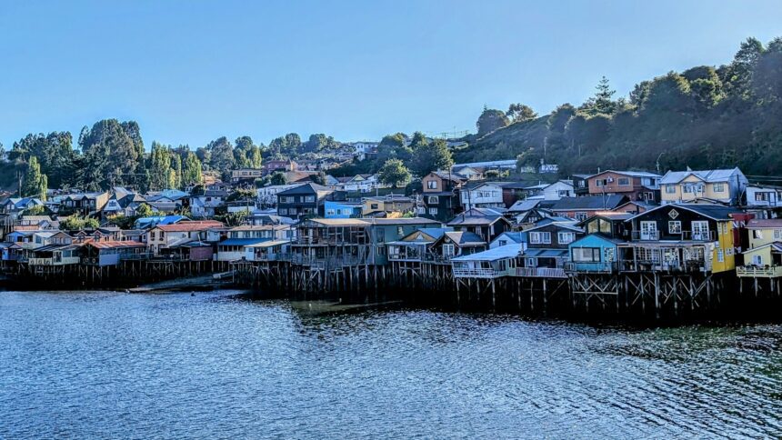A large grouping of houses on the edge of a shore with stilts going in to the water - Chiloe Island