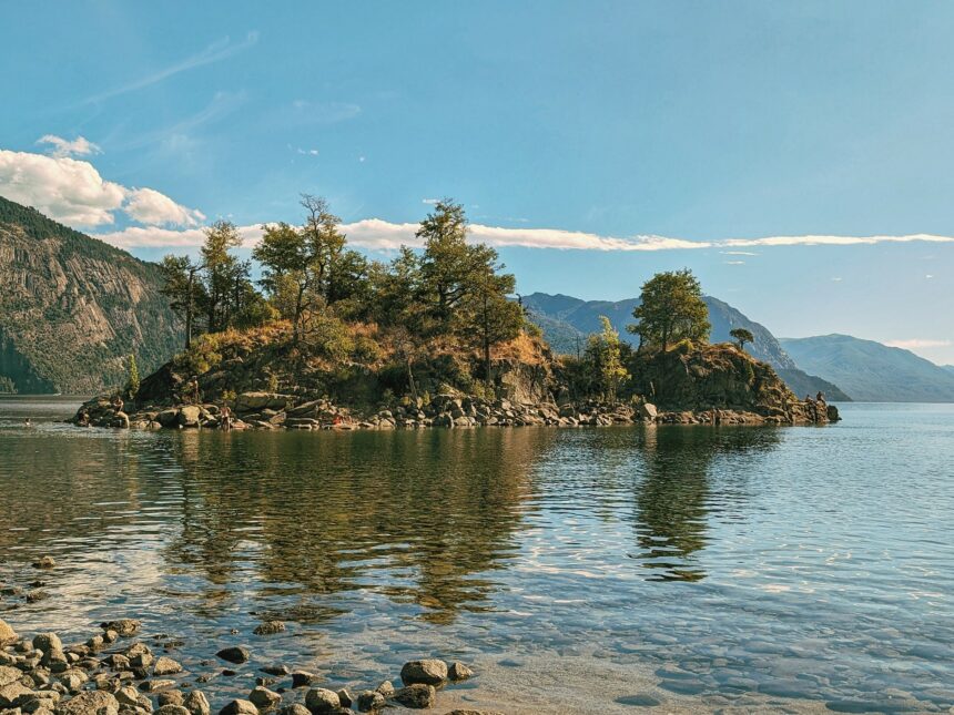 Trees and the rocky coastline of a lake - Route of the Seven Lakes - traveling to Patagonia