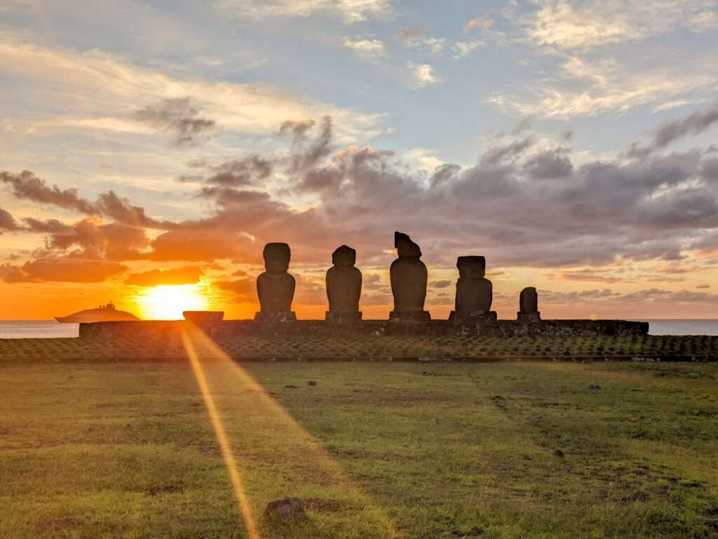 The sun setting over a line of stone statues - Easter Island itinerary