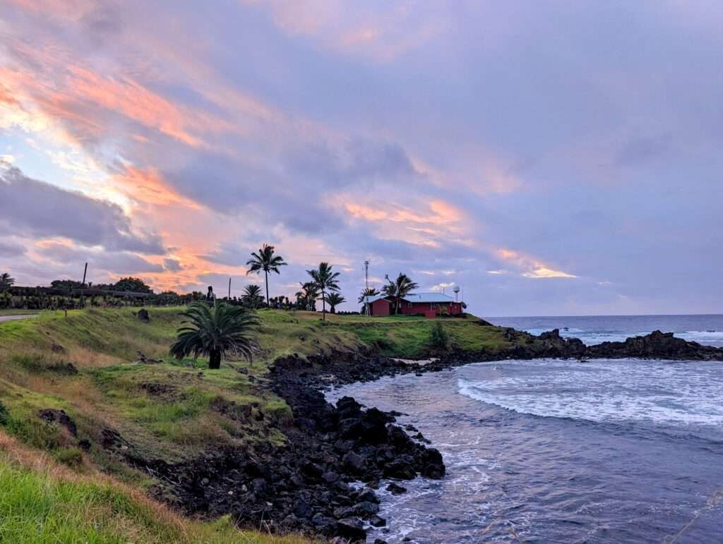A purple and pink sunset over the tropical coastline of an island - Easter Island itinerary