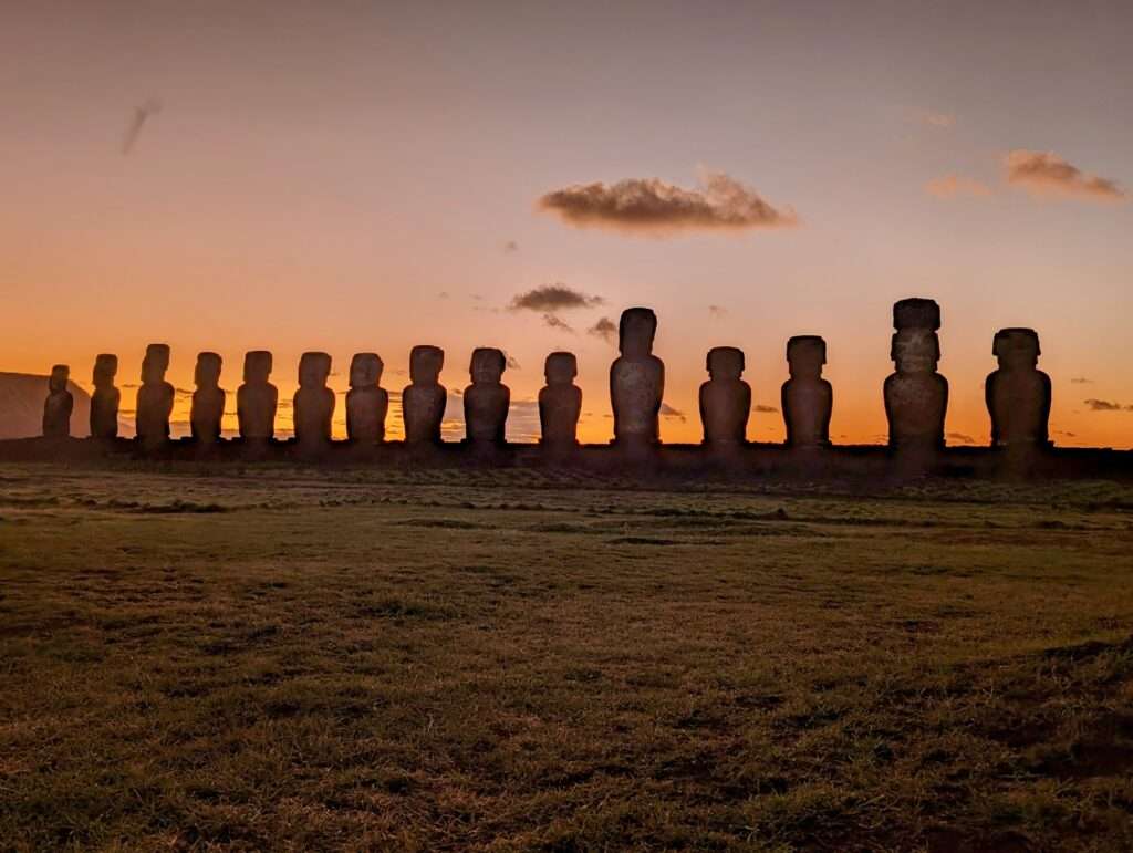 The sun rising over a line of stone statues - Easter Island itinerary