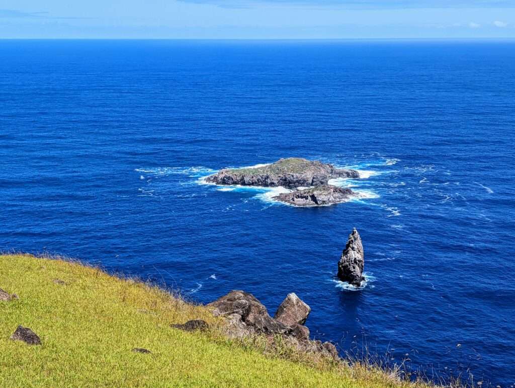 Some small rocky islands off the coast of a hill - How to Visit Easter Island