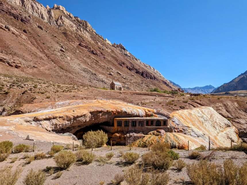 A building tucked under an orange and red rocky mountain - Things to do in Mendoza