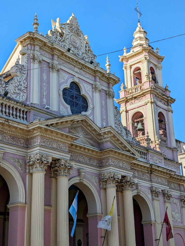 A pink and yellow cathedral in the center of Salta that can be seen when visiting Salta