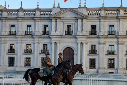 Two people on horses in front of a white government palace - Things to do in Santiago