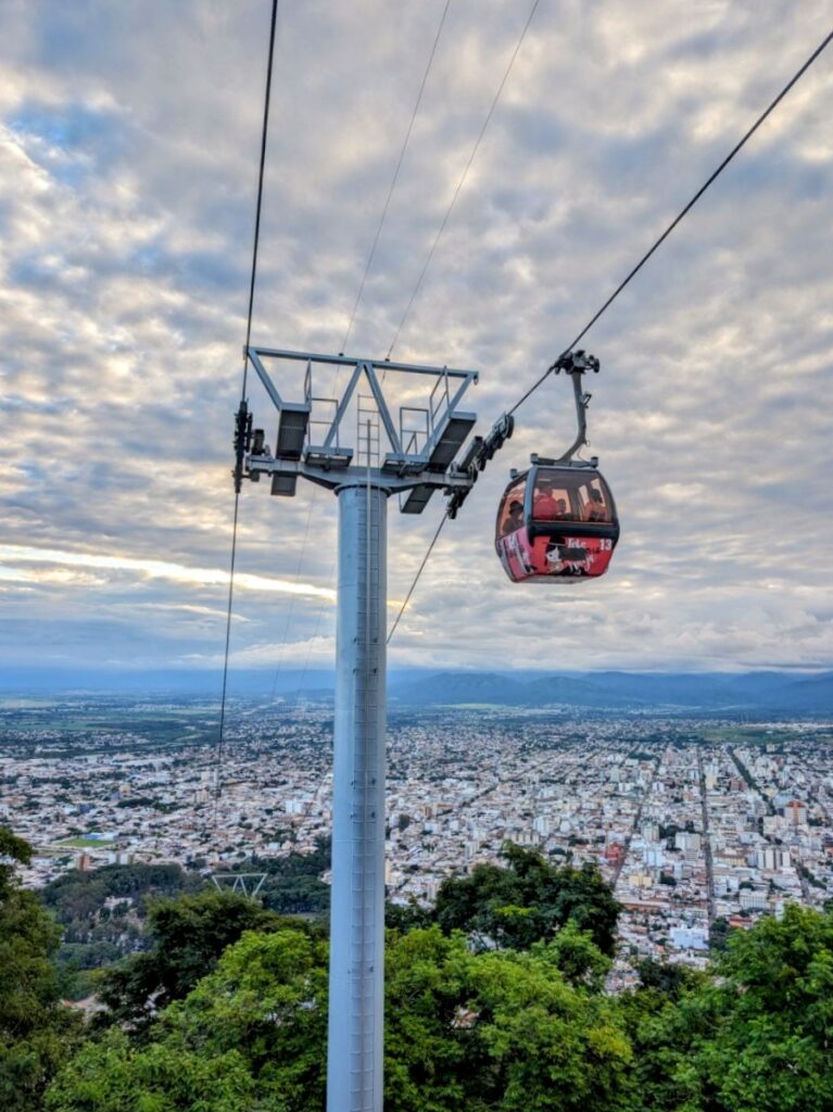 A cable car above a city that can be experienced when visiting Salta