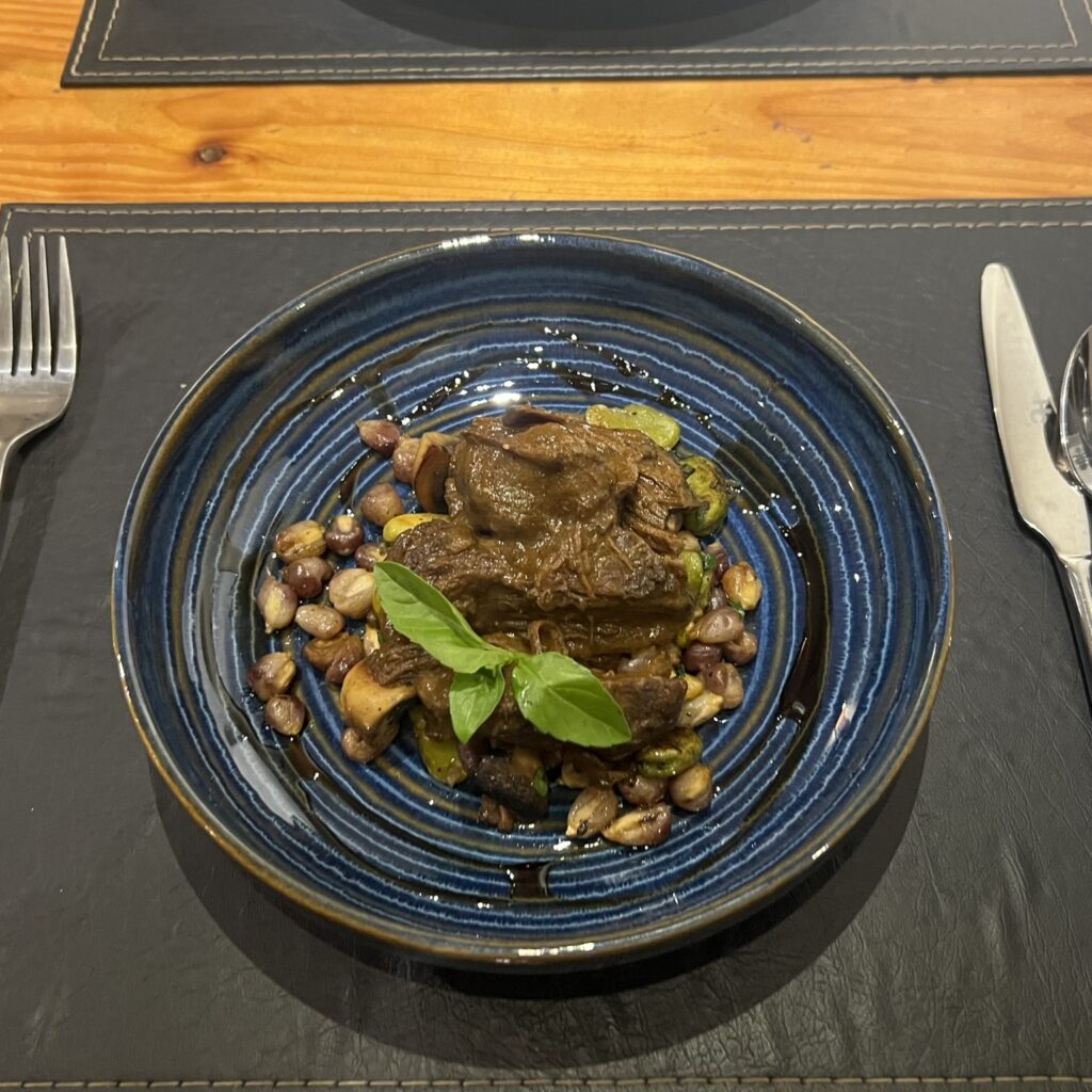 A steak-like meat dish on a black plate