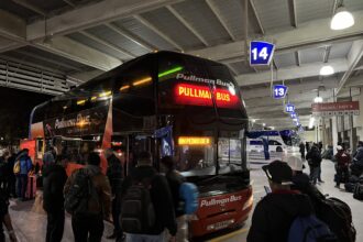 A bus at a station at night used to cross the border between Chile and Argentina