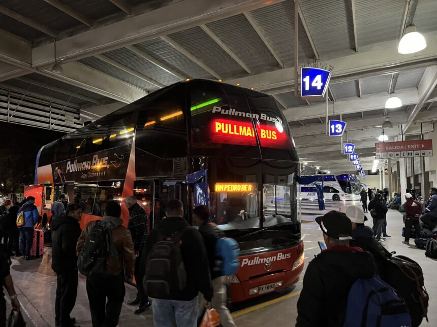 A bus at a station at night used to cross the border between Chile and Argentina