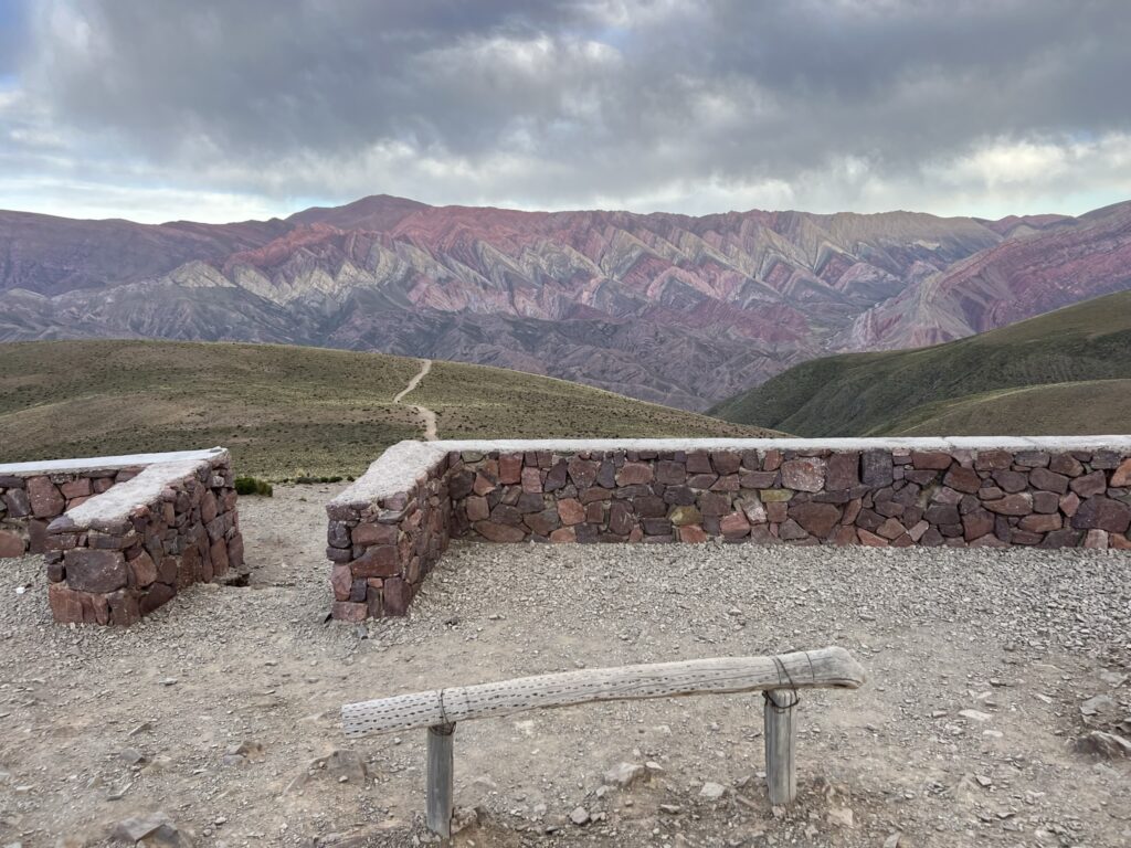A bench and wall in front of a mountain with 14 natural colors