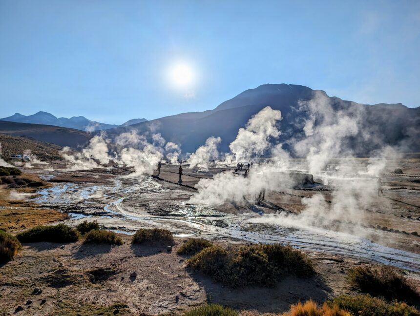 A landscape of geysers with the sun rising over the mountains behind - San Pedro de Atacama desert itinerary