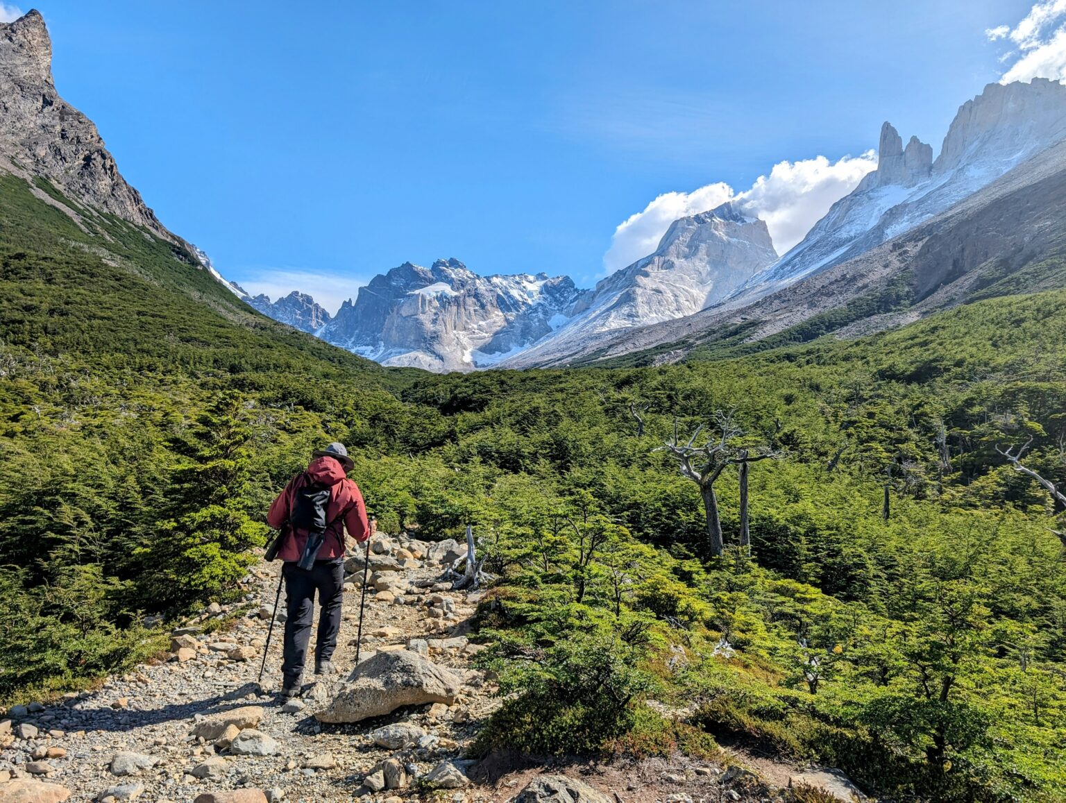 A man hiking through the mountains of Torres del Paine in Patagonia where you may need long term travel insurance