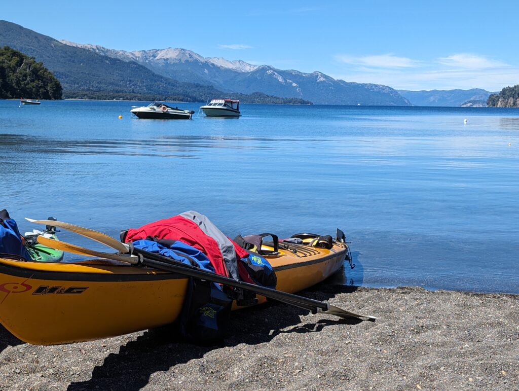 A kayak on a lake surrounded by mountains where you may need travel insurance