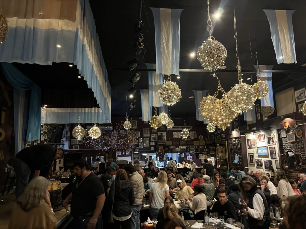 The interior of a busy restaurant with a stage on the left