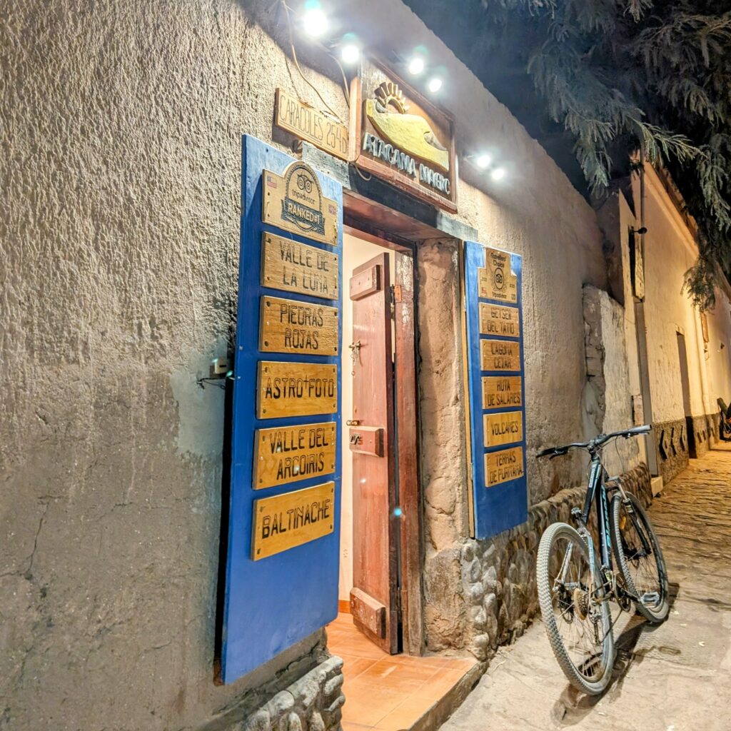 The entrance to a retail with descriptions of offerings on the open door in San Pedro de Atacama