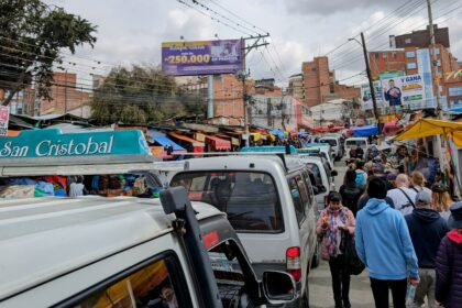 Buses and cars and people flowing through the city showing different La Paz transportation