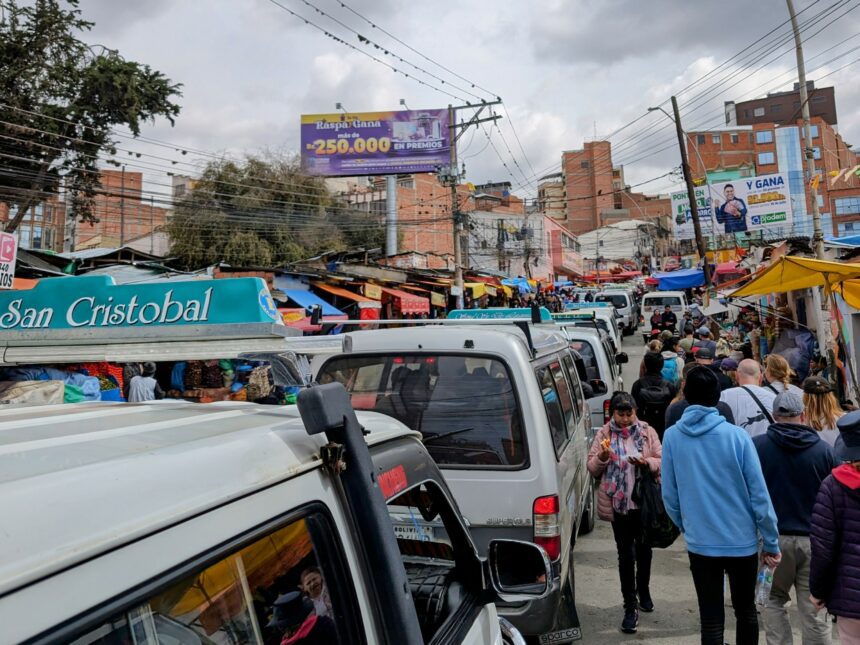 Buses and cars and people flowing through the city showing different La Paz transportation