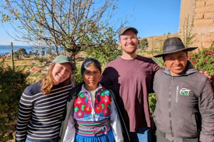 Four people smiling at the camera during a homestay on Amantani Island in Lake Titicaca