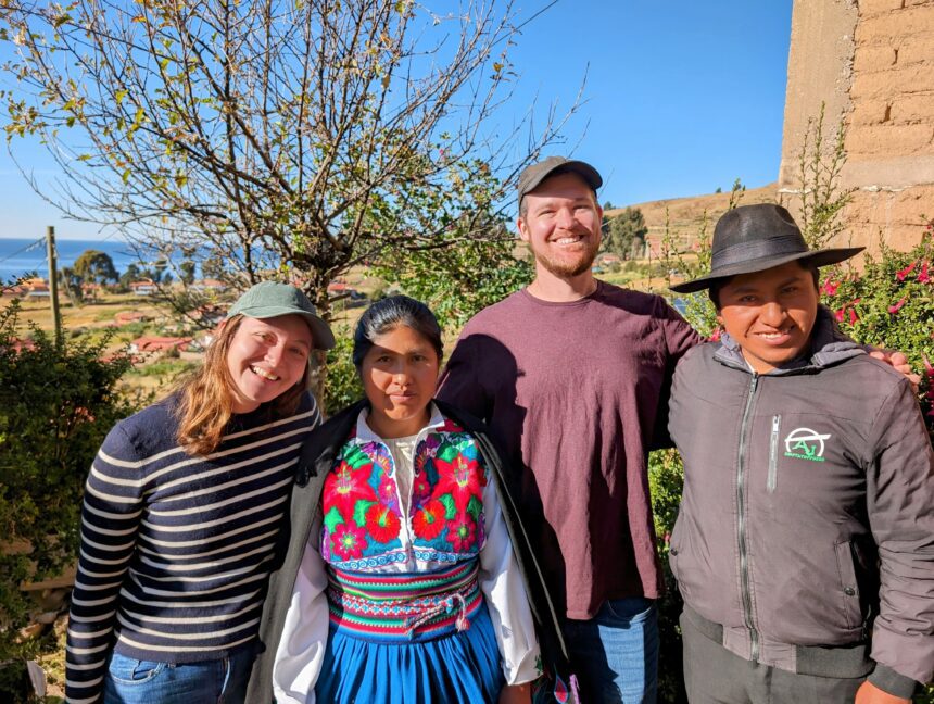 Four people smiling at the camera during a homestay on Amantani Island in Lake Titicaca
