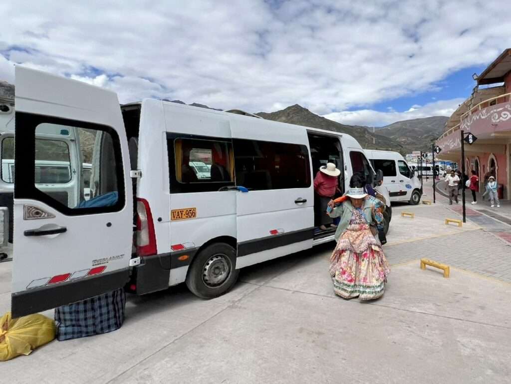 A woman dressed in indigenous clothing going on the minibus to go from Arequipa to Colca Canyon