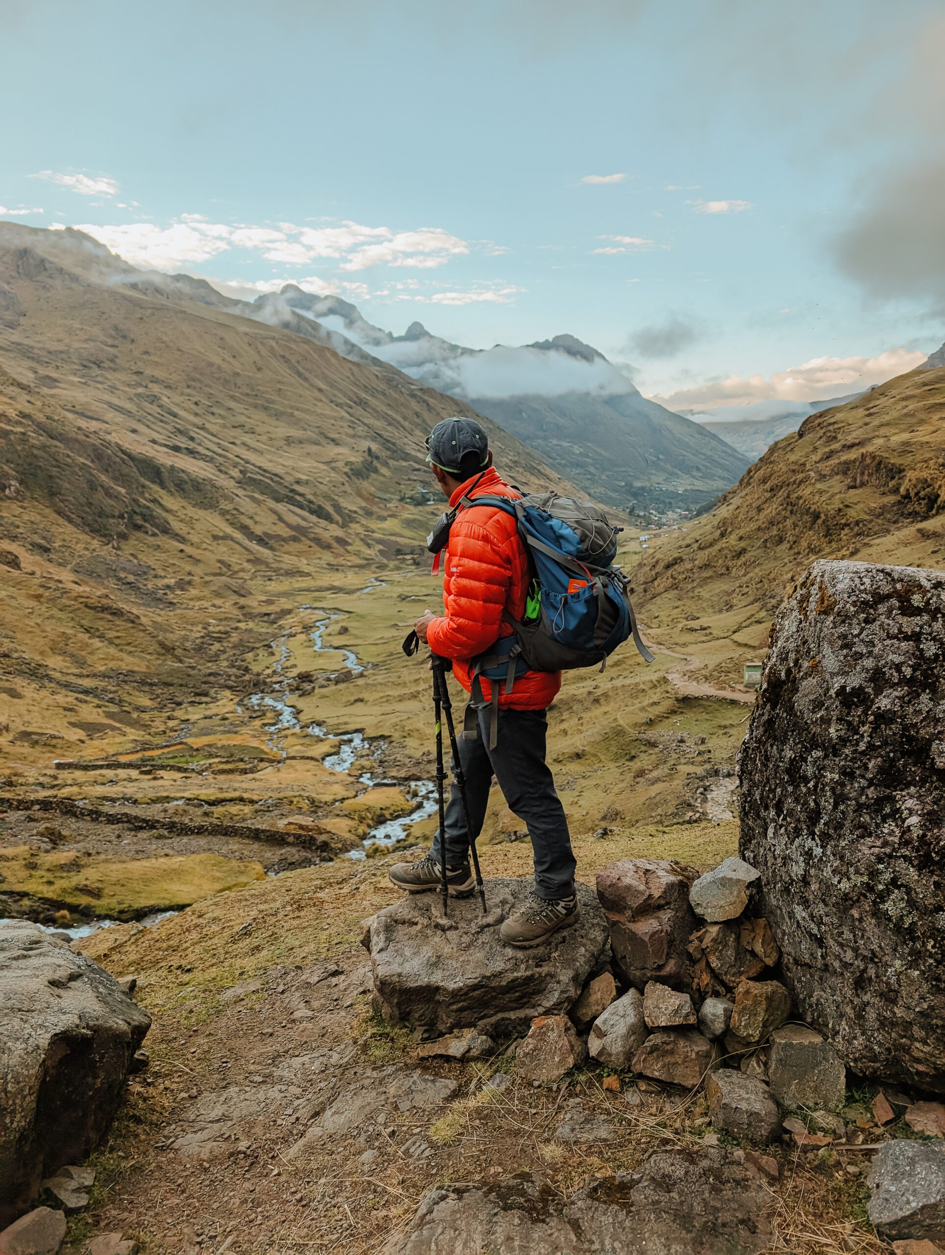 A man in hiking gear looking out over a valley of the Lares trek
