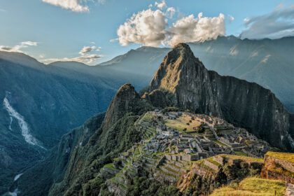 Visiting Machu Picchu with rays of sunshine coming over the mountains at sunset - visited with Alpaca Expeditions, one of the best Inca trail tour operators