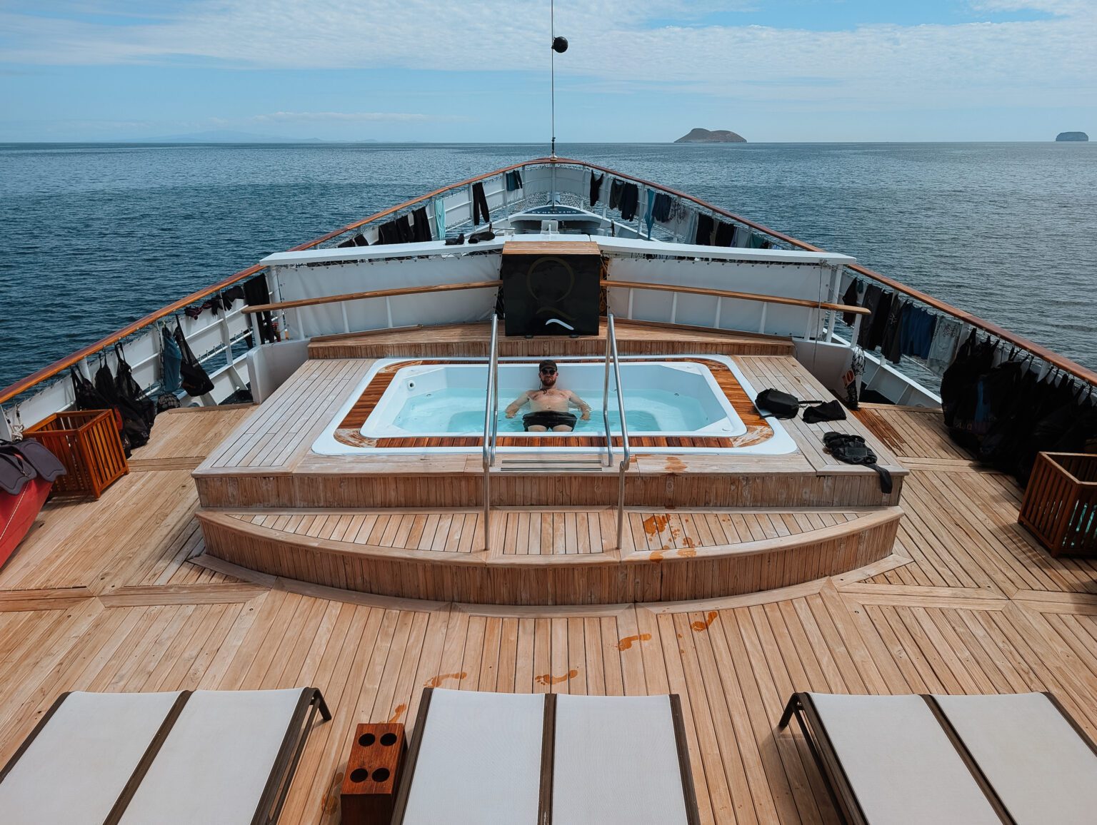 A person in the hot tub on the front of a Galapagos Islands yacht cruise with Quasar Expeditions