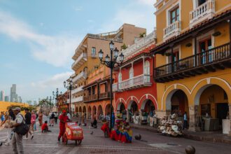 The main square at the entrance of the walled city of Cartagena with colorful buildings and local vendors - things to do in Cartagena