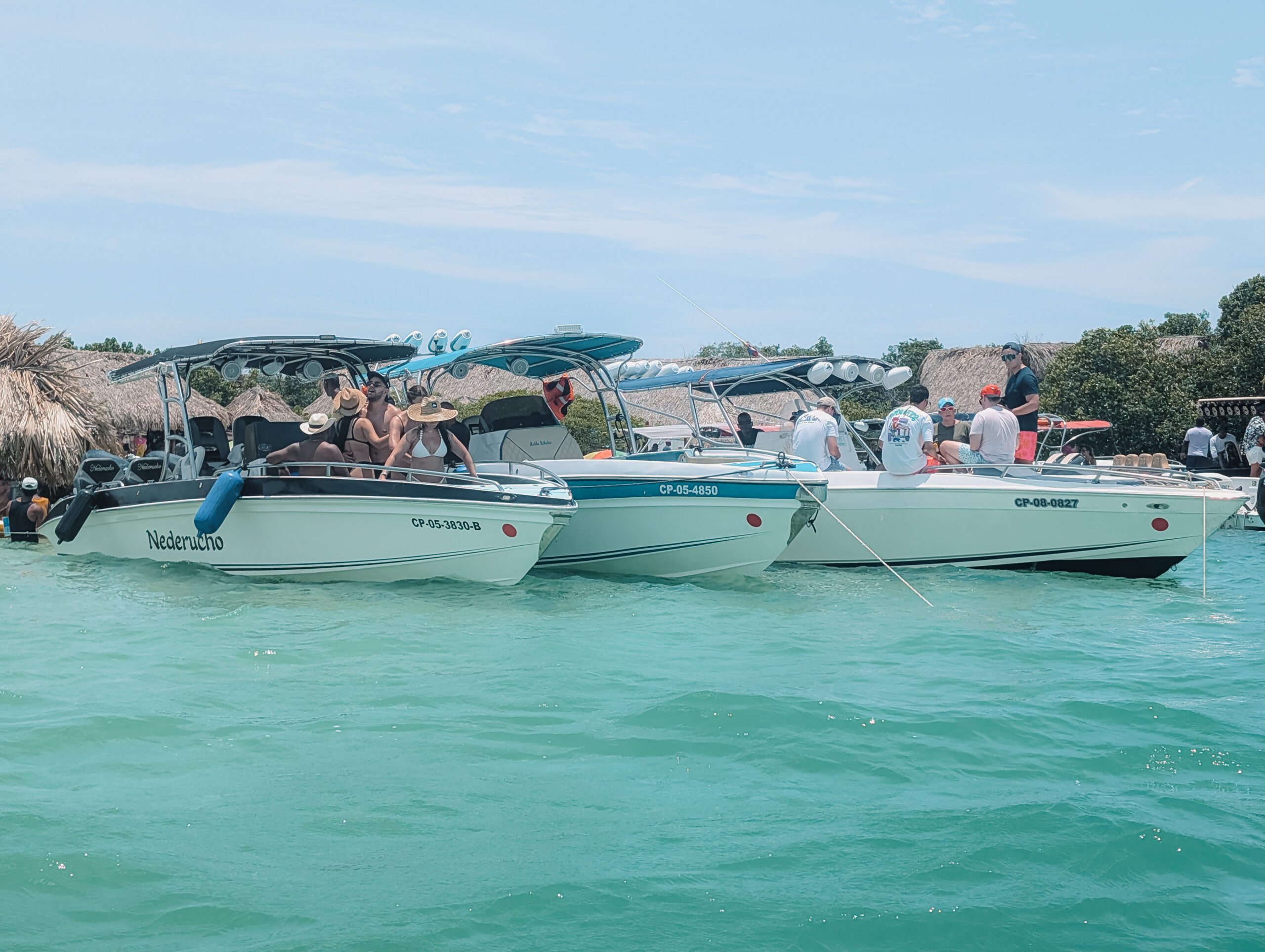 Three boats tied together at the party island of Cholon near Cartagena