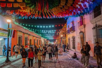 The main pedestrian street in the city center of Oaxaca with colorful flags above it decorating it