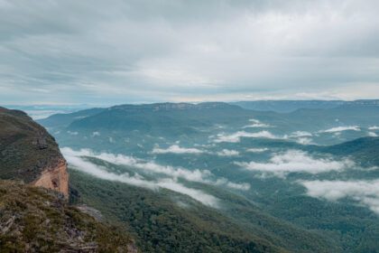 The view over a large valley with blue-like trees and some cloud cover - Blue Mountains 1 day itinerary