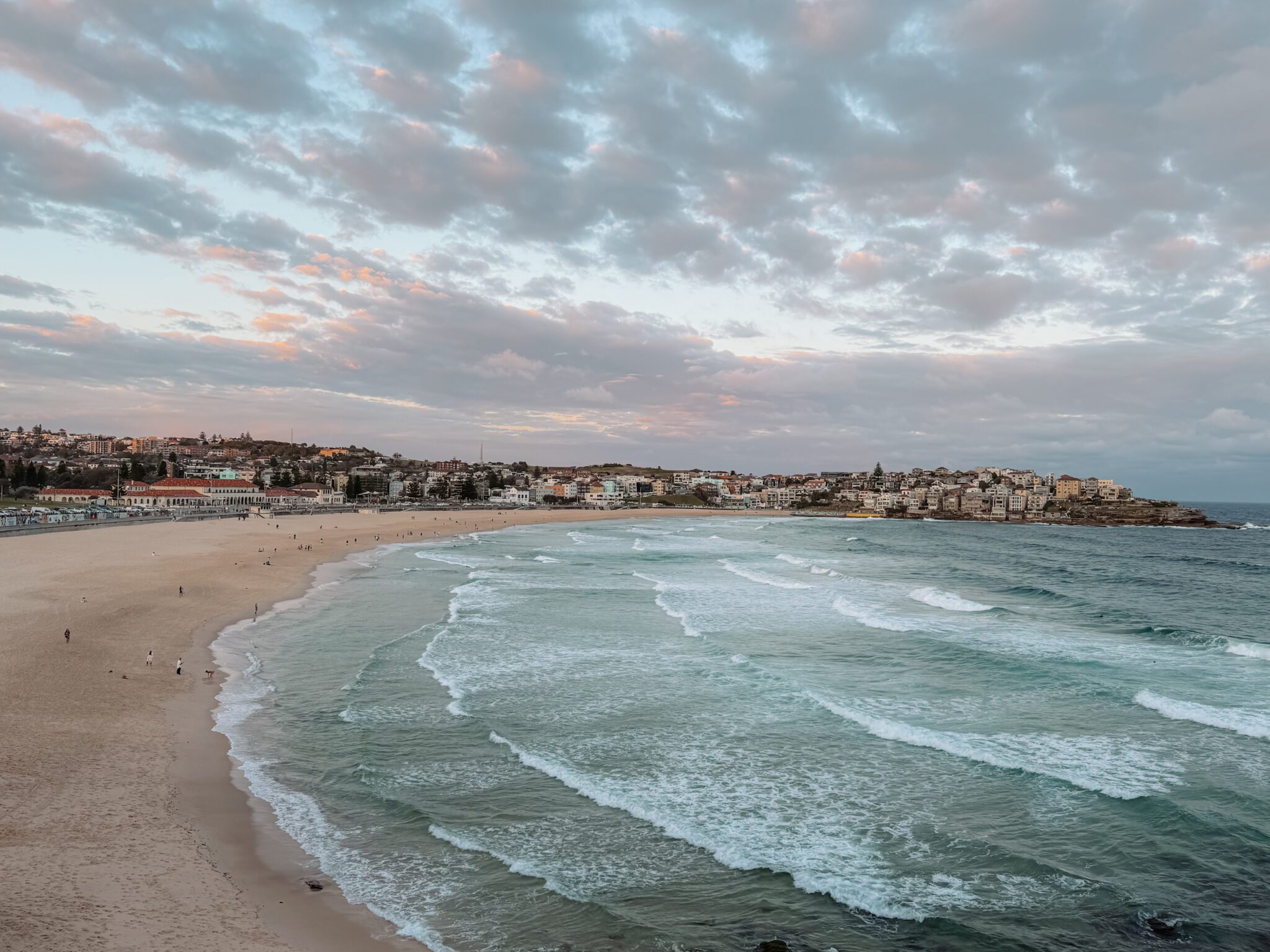 Sunset over a large beach with buildings at the coastline - Sydney itinerary