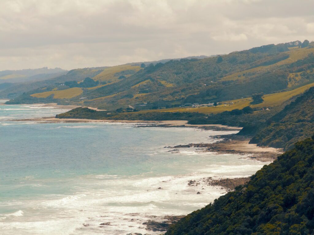 A view over the ocean, a beach, and the Great Ocean Road winding along a coast - Great Ocean Road itinerary