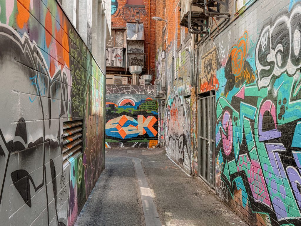 An alley with murals and graffiti on the walls, helping answer is Melbourne worth visiting